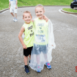 Two kids wearing "First 5k Ever" shirts posing for their picture.