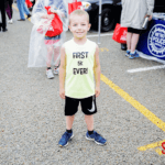 A child wearing a shirt that says "First 5k Ever!"