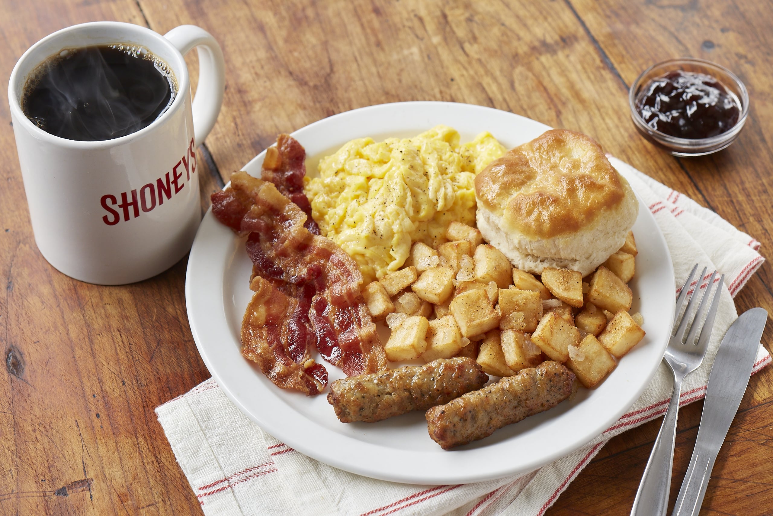 Shoney’s breakfast with eggs, bacon, sausage, potatoes, biscuit, and coffee.
